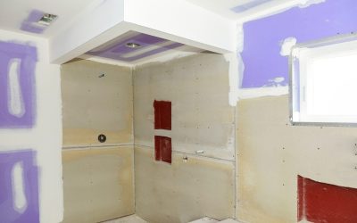 Bathroom remodel progresses as drywall is smoothed, covering seams and screws with tape and spackle mud